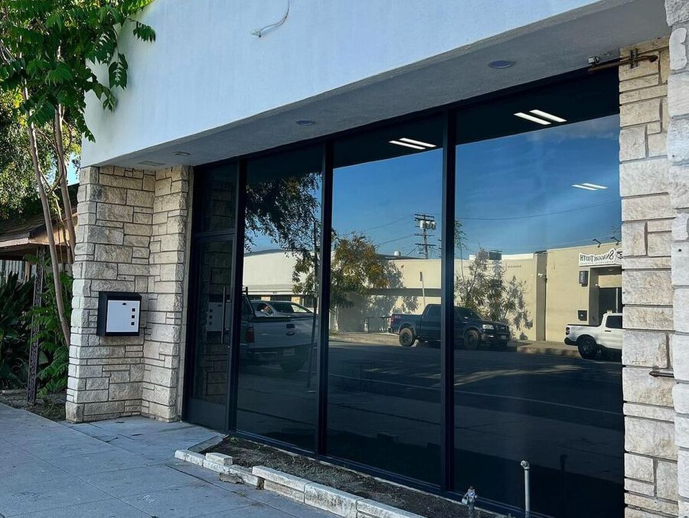 Dark solar control film installed across the storefront glass of a Los Angeles commercial unit